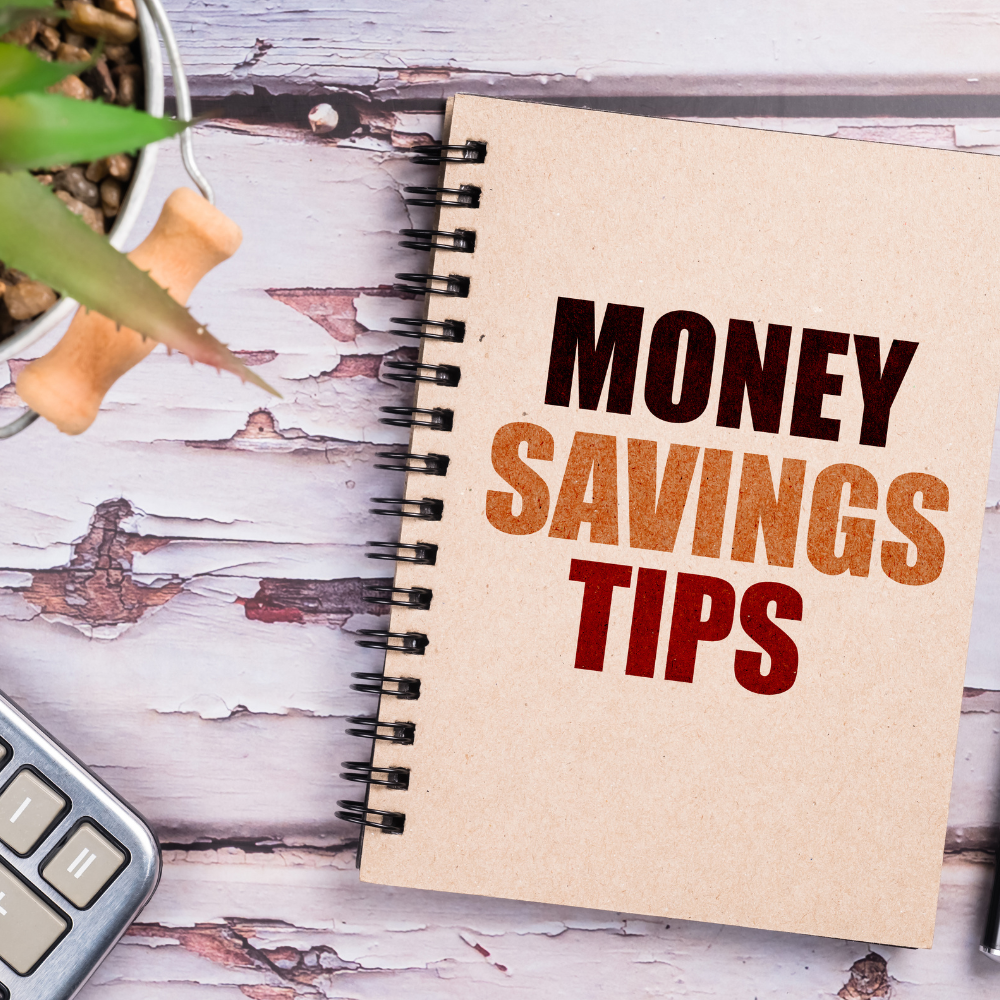 money saving tips notebook on table with plant and calculator